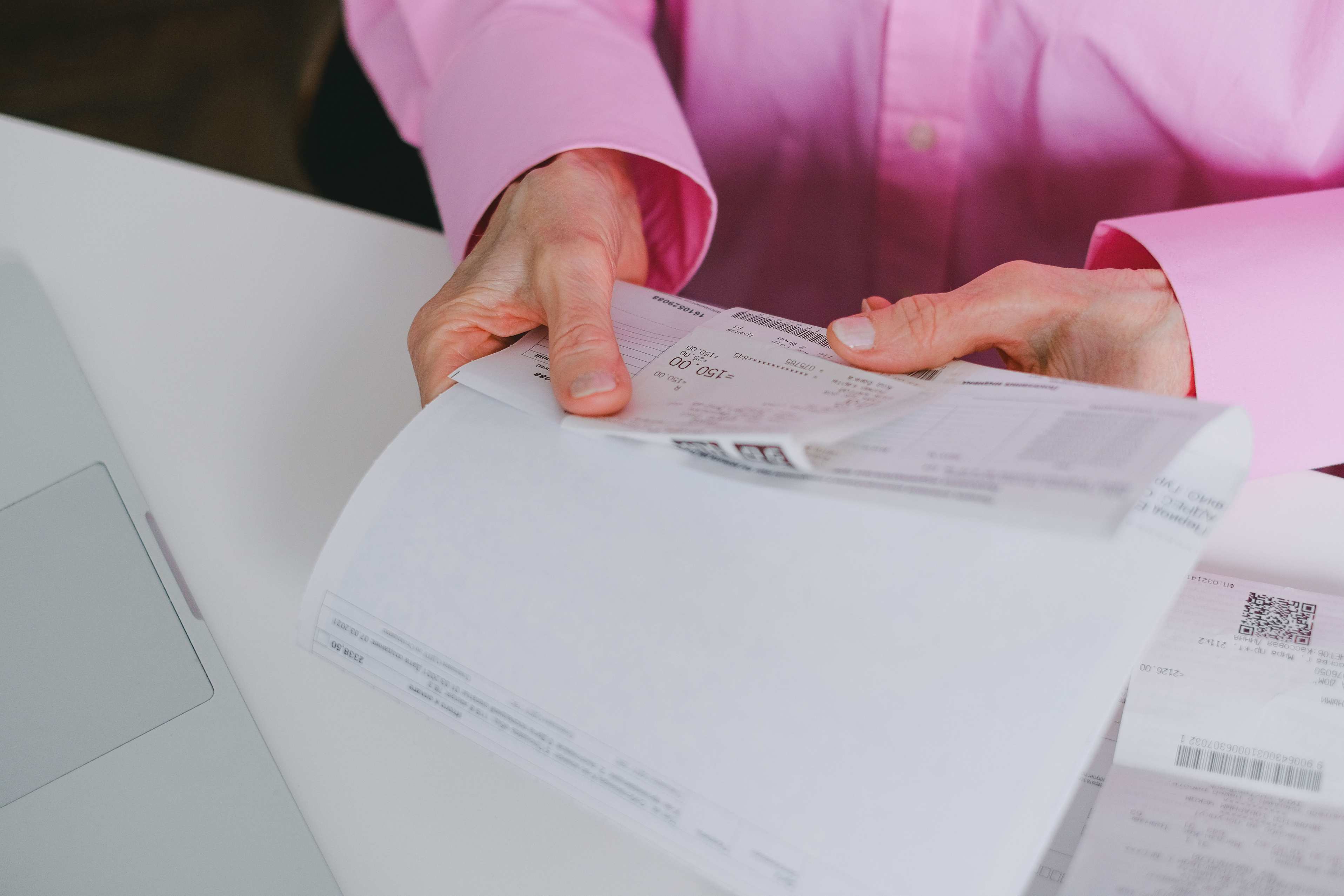 Belege und Taschenrechner neben Notizblock auf dem Tisch, receipts und paper documents